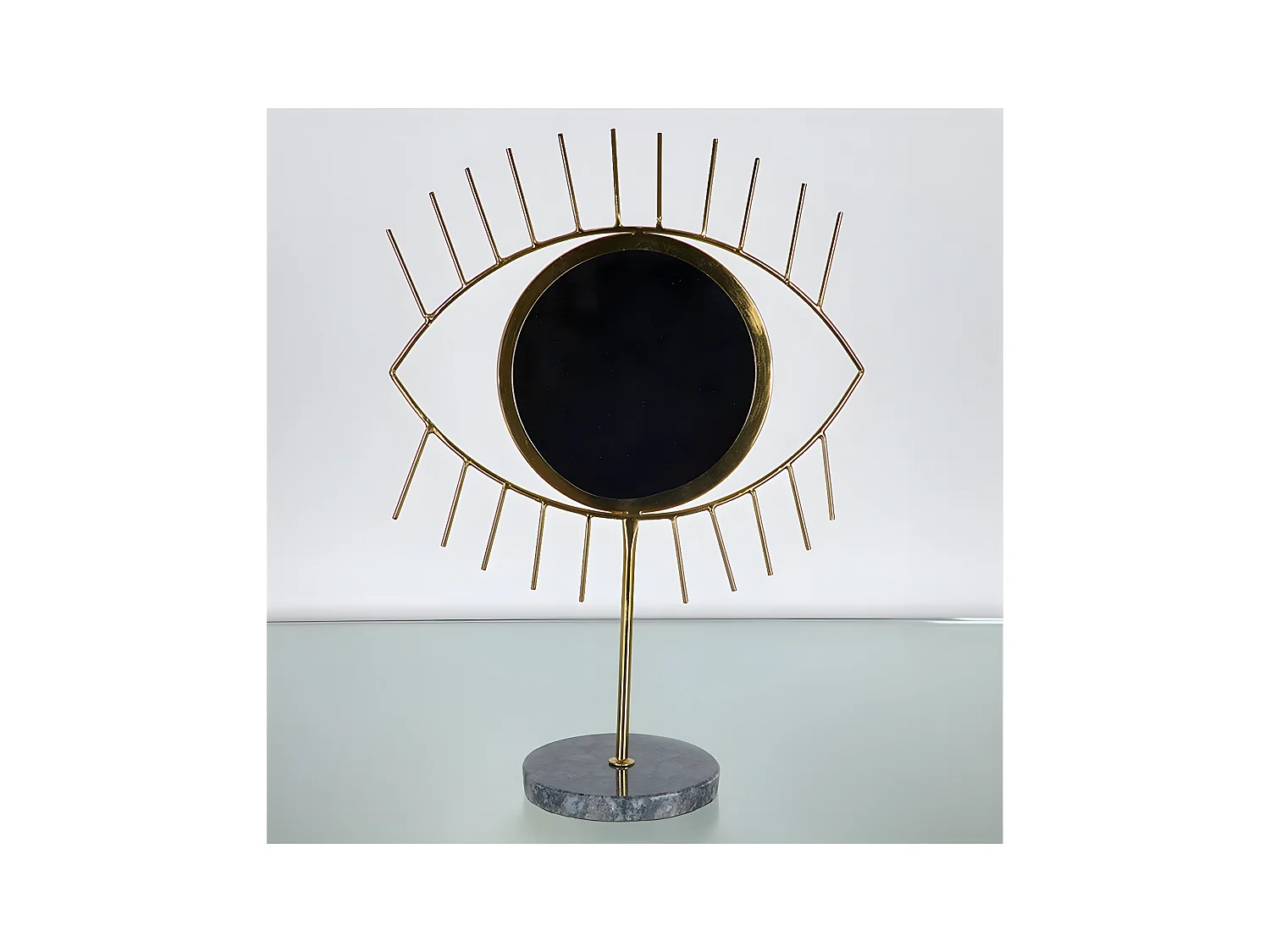 Ojo negro de metal dorado con base de marmol oraculo