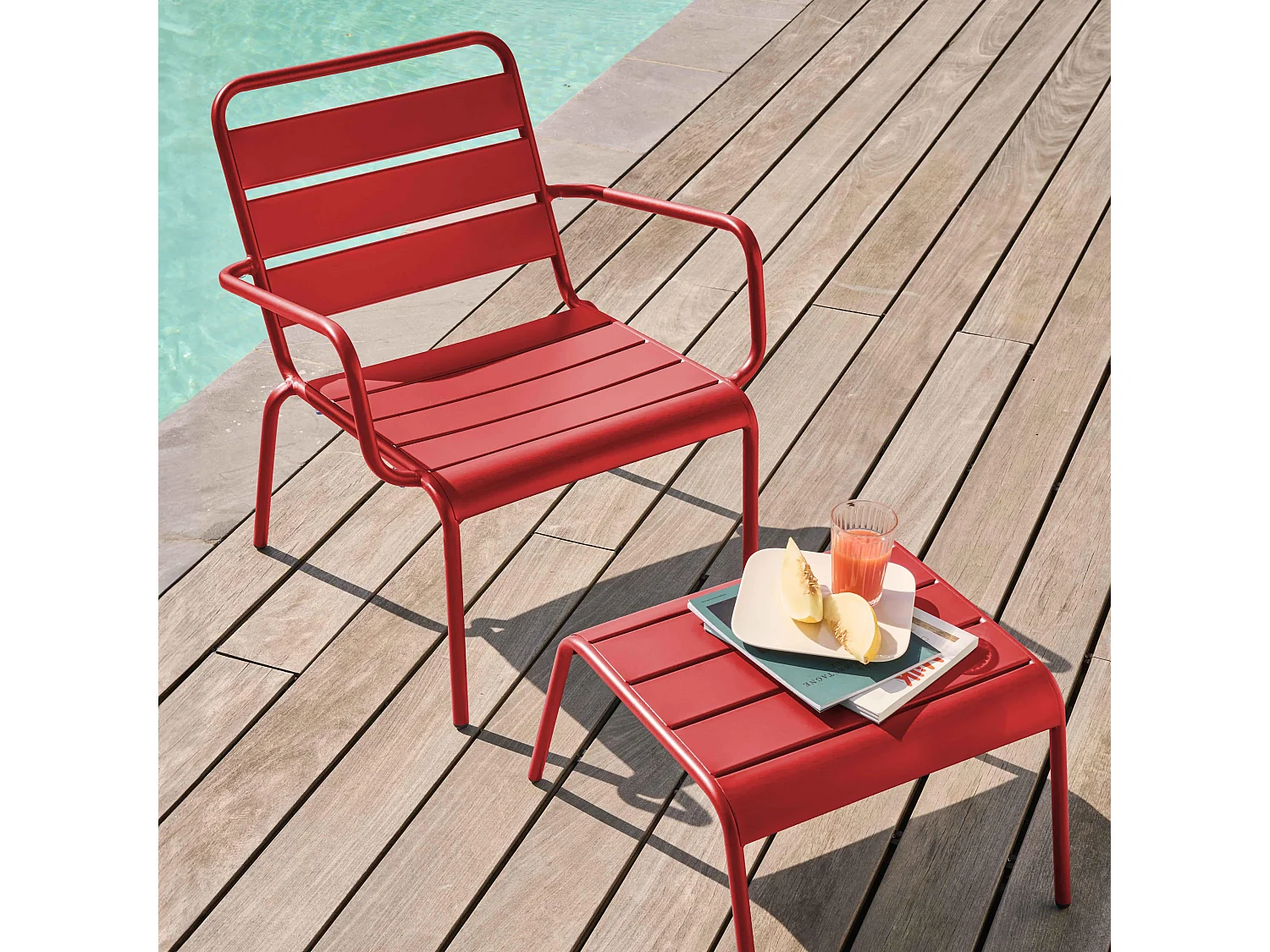 Ligstoel en voetenbankje van rood metaal