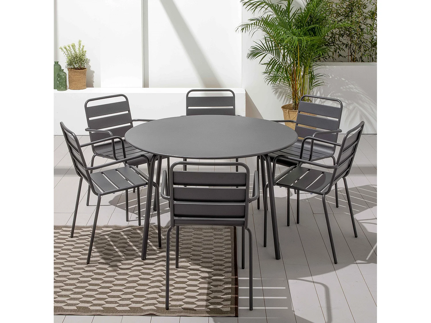 Set van een ronde tuin tafel en 6 grijze stalen fauteuils