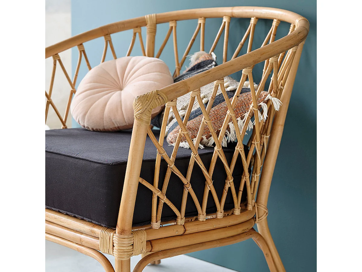 Sillón de ratán marrón con cojín negro