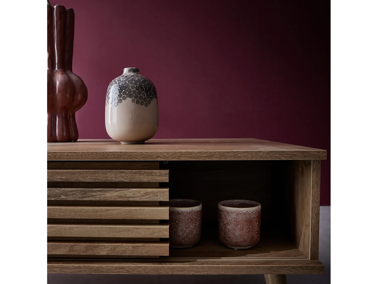 Table basse scandinave avec portes coulissantes décor bois rainuré et niches de rangement