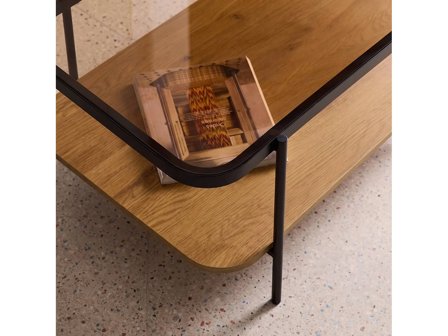 Mesa de centro vintage de metal negro con tapa de cristal y decoración