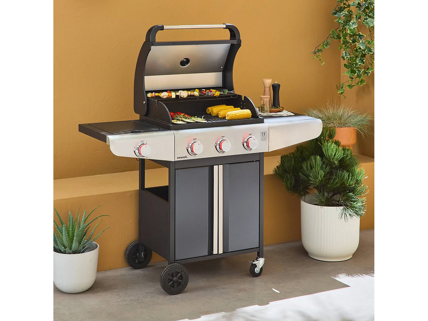 Barbecue au gaz - Bazin 3 Gris anthracite -  Cuisine extérieure 3 brûleurs + 1 feu latéral avec tablettes et thermomètre. rangement. roues