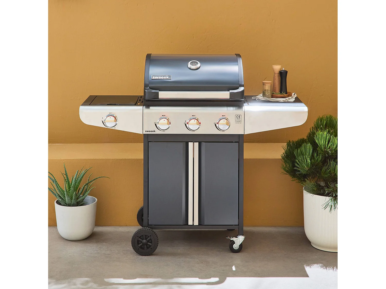 Barbecue au gaz - Bazin 3 Gris anthracite -  Cuisine extérieure 3 brûleurs + 1 feu latéral avec tablettes et thermomètre. rangement. roues