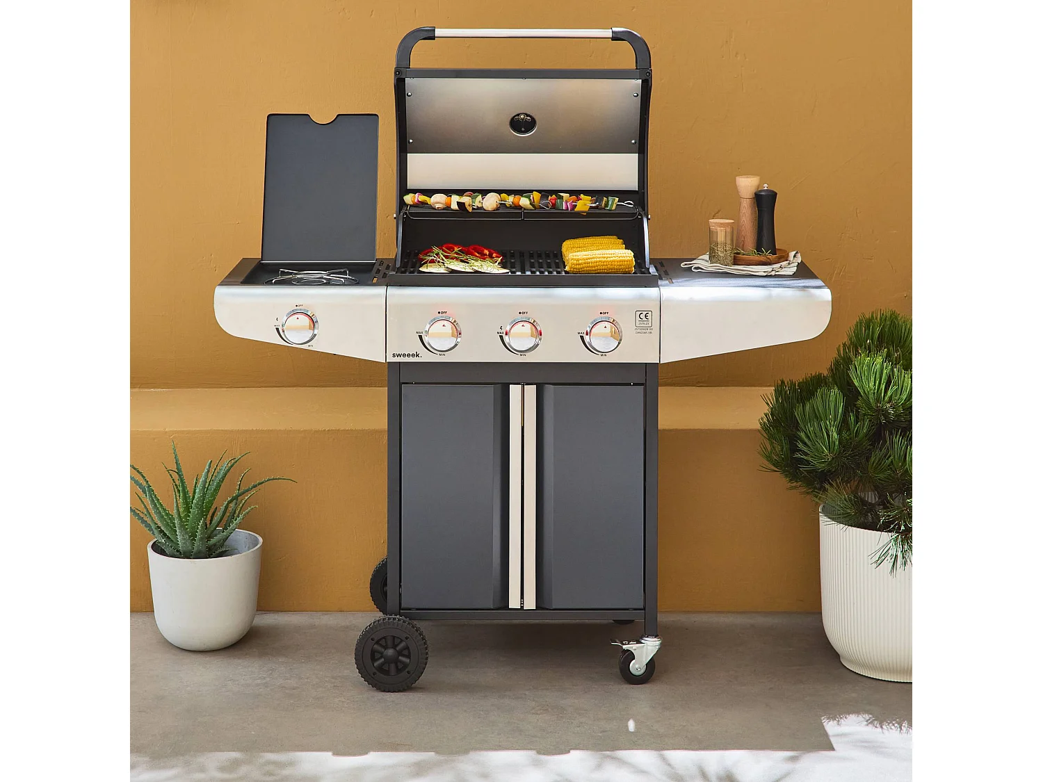 Barbecue au gaz - Bazin 3 Gris anthracite -  Cuisine extérieure 3 brûleurs + 1 feu latéral avec tablettes et thermomètre. rangement. roues