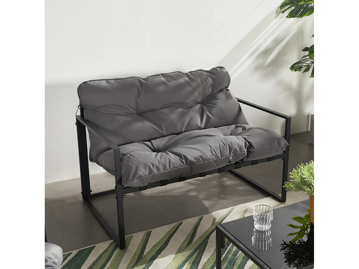 Eigentijdse 4-zits tuinset in zwart met grijze kussens en salontafel van gehard glas