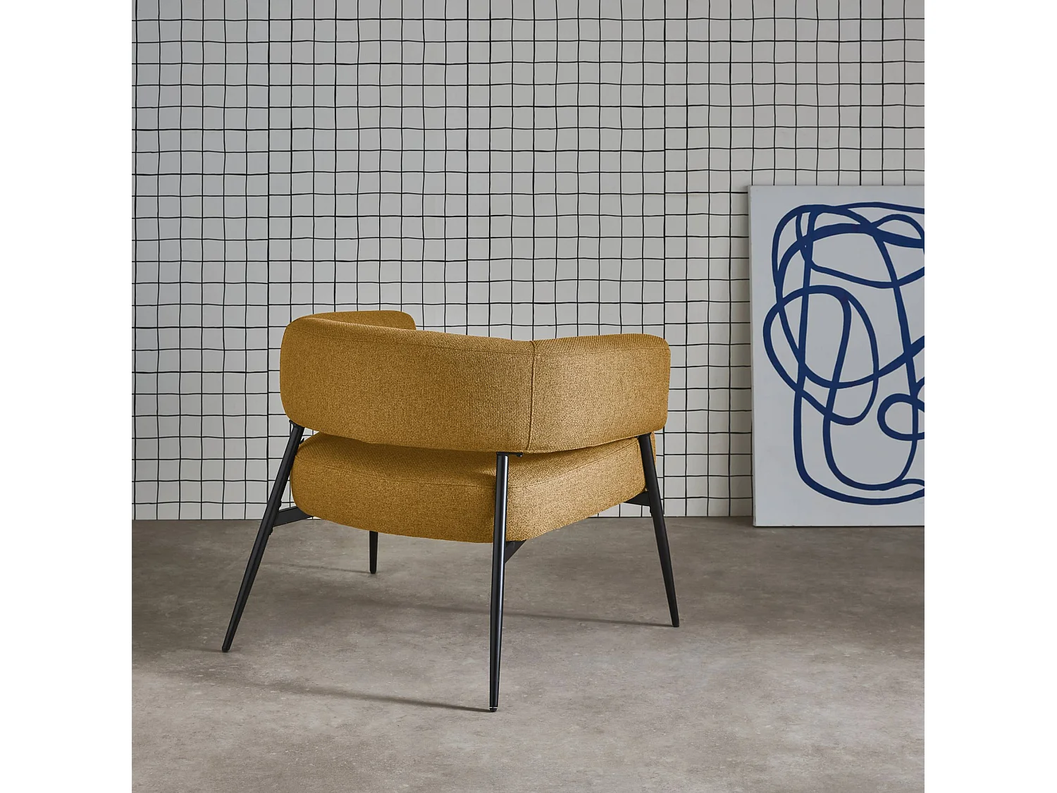 Sillón de tela con respaldo curvo y patas de metal mostaza