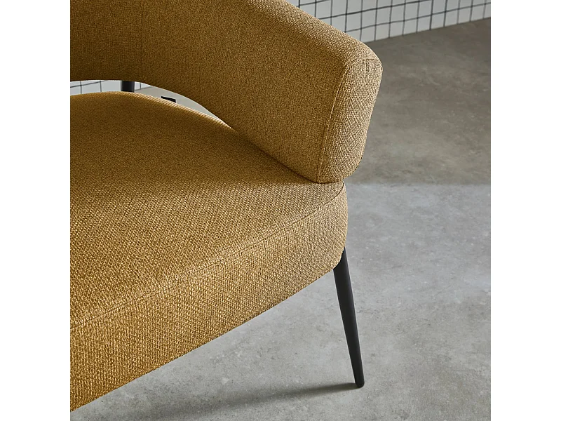 Sillón de tela con respaldo curvo y patas de metal mostaza