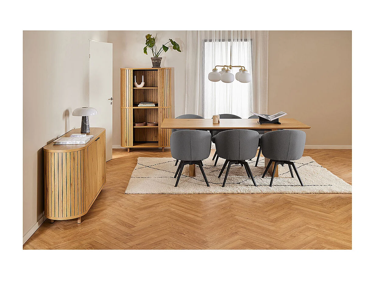 Sedia da pranzo Darlene con braccioli in tessuto grigio.