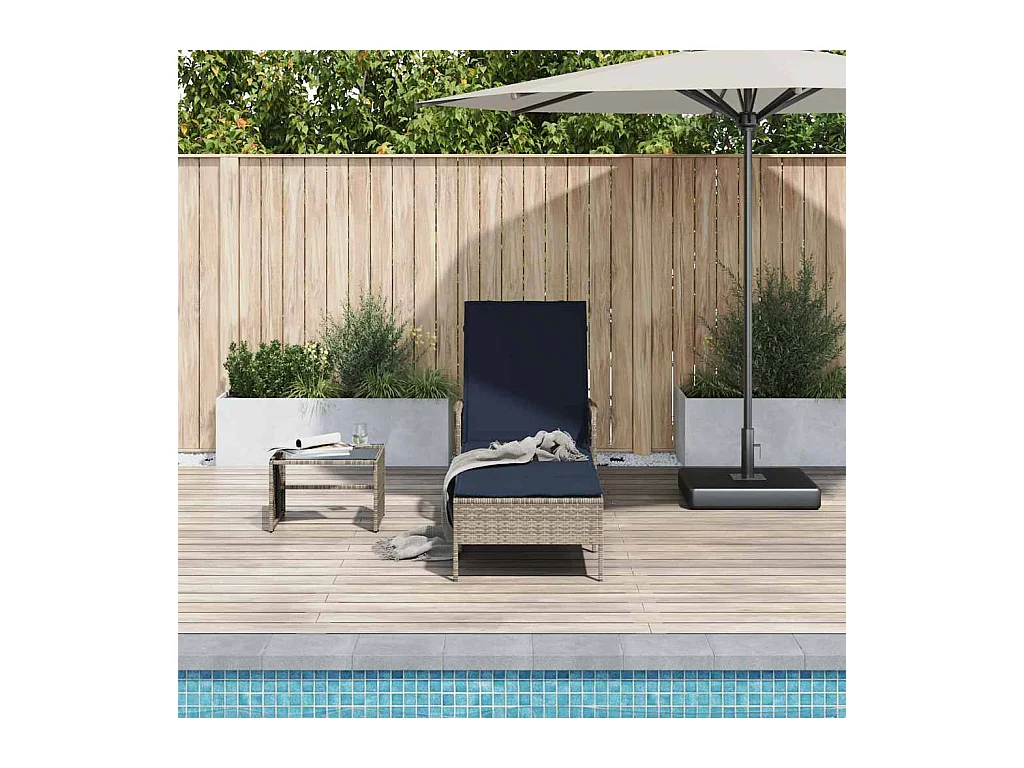 Chaise longue avec coussin en poly rotin gris.