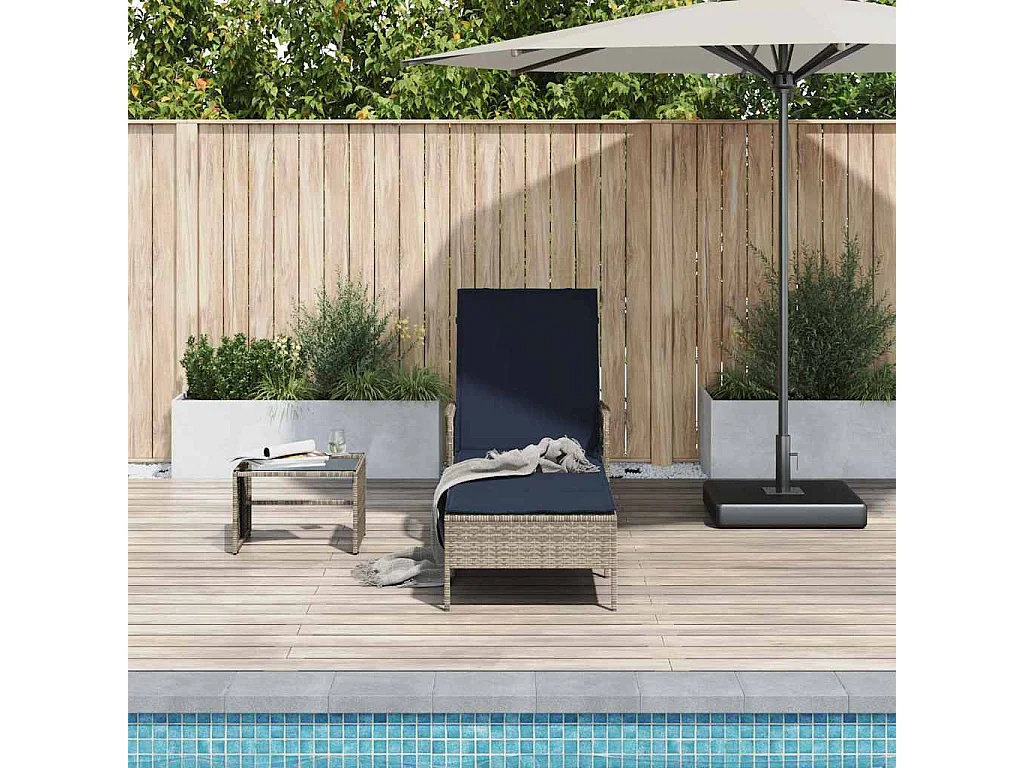 Chaise longue avec coussin en poly rotin gris.