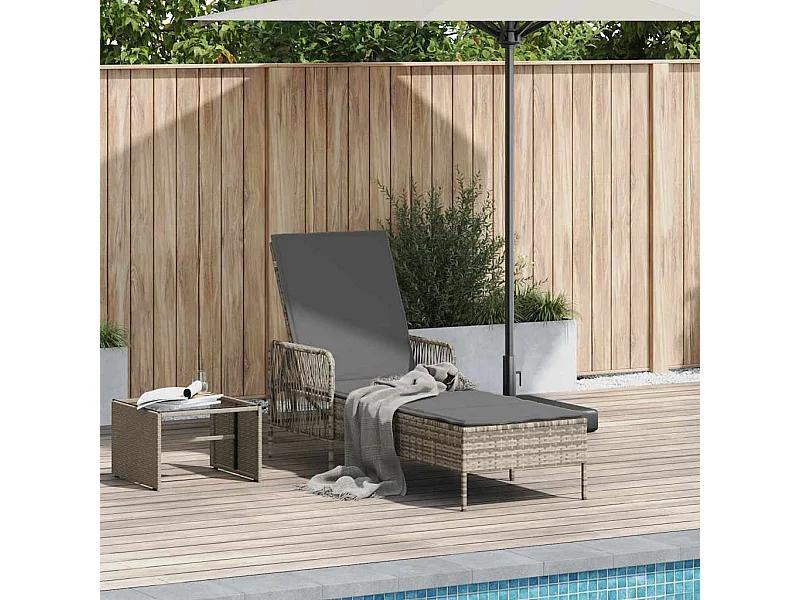 Chaise longue avec coussin gris en poly rattan.