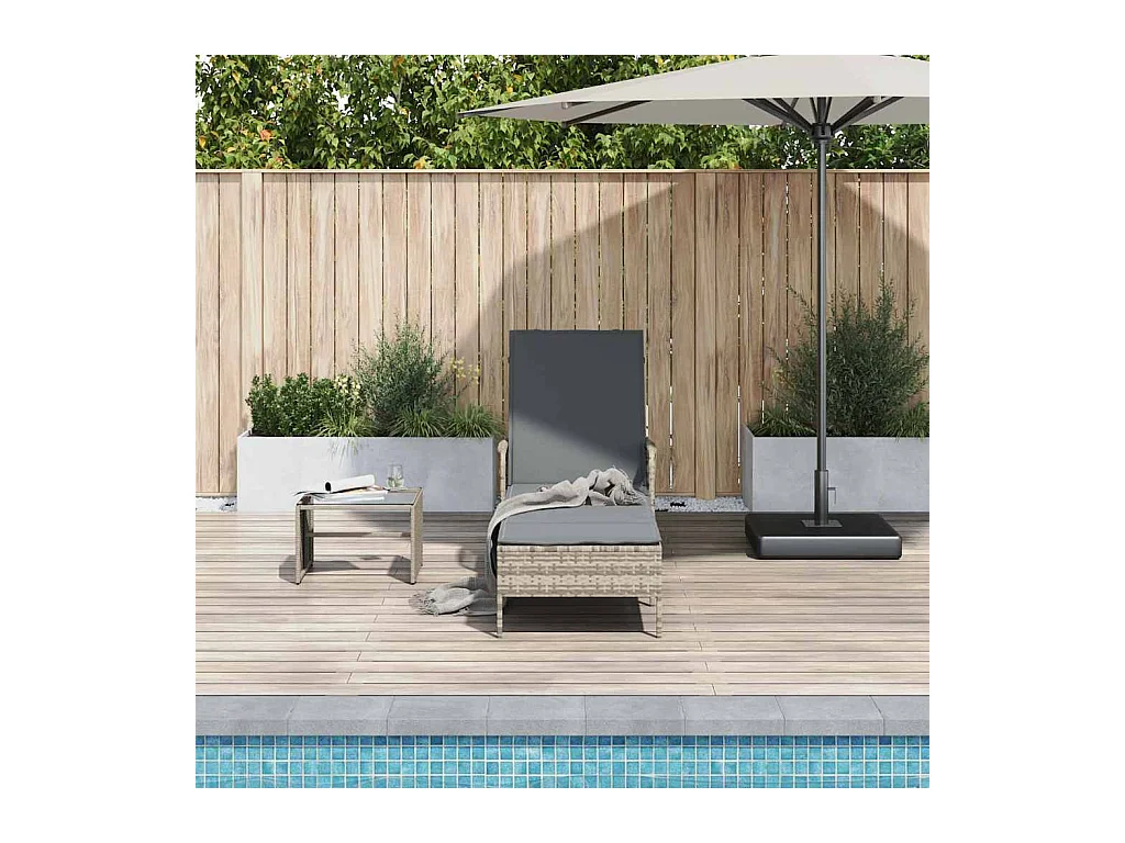 Lounge stoel met grijs poly rotan kussen.