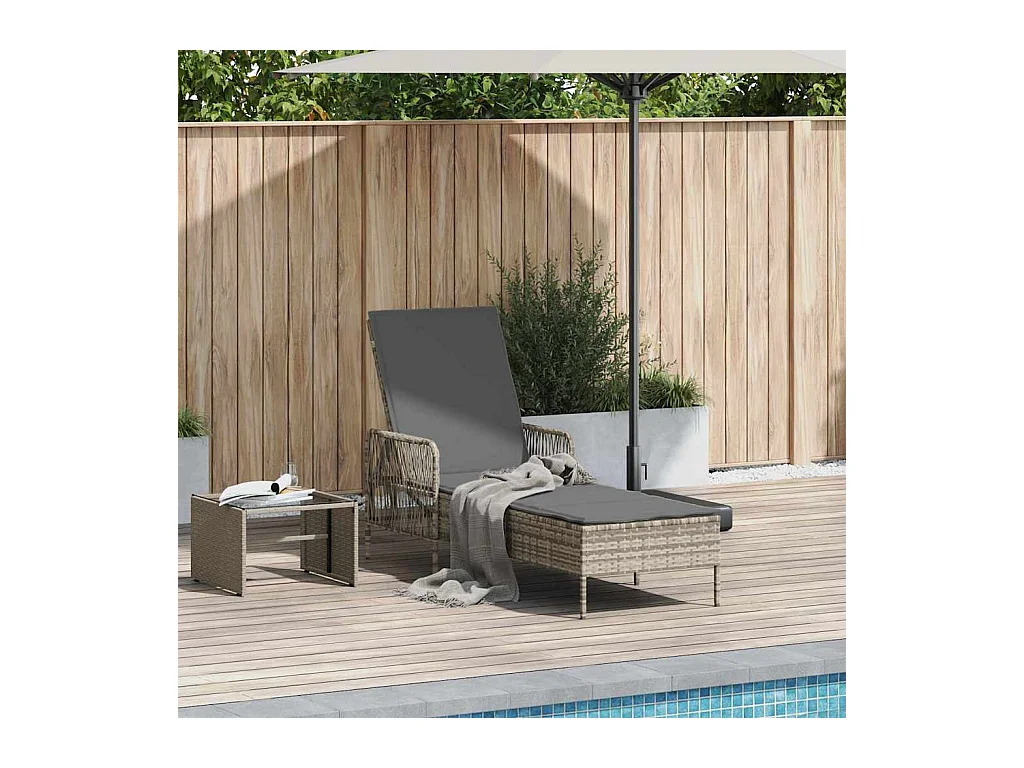 Chaise longue avec coussin gris en poly rattan.