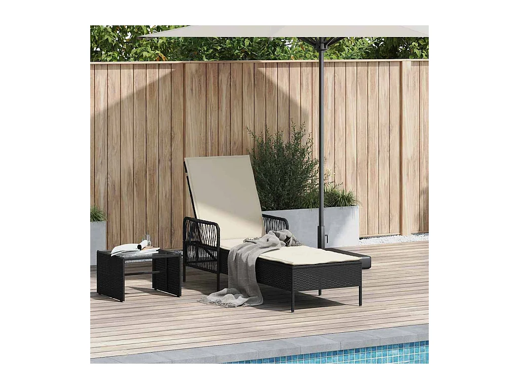 Tumbona con cojín de ratán sintético negro.