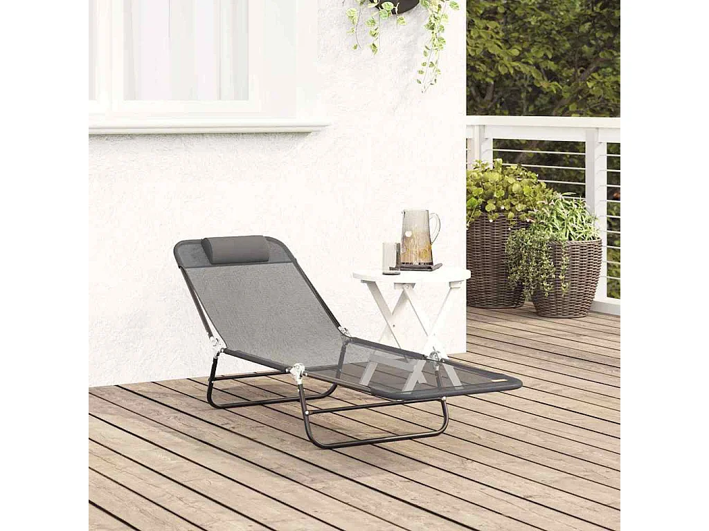 Chaise longue pliante avec repose-tête en textilène gris.