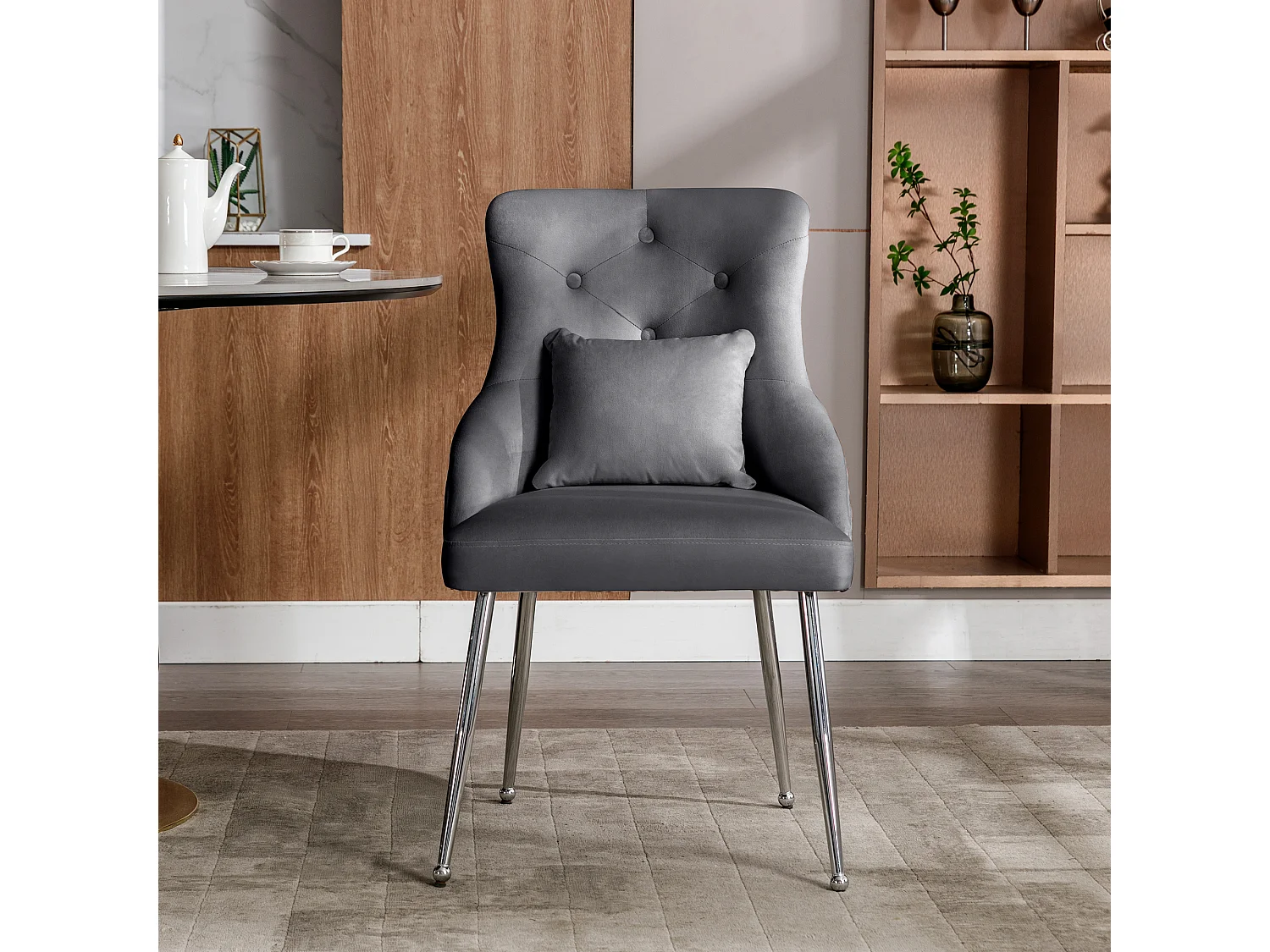 Silla de comedor de terciopelo gris con cojín lumbar y diseño moderno y patas de metal.