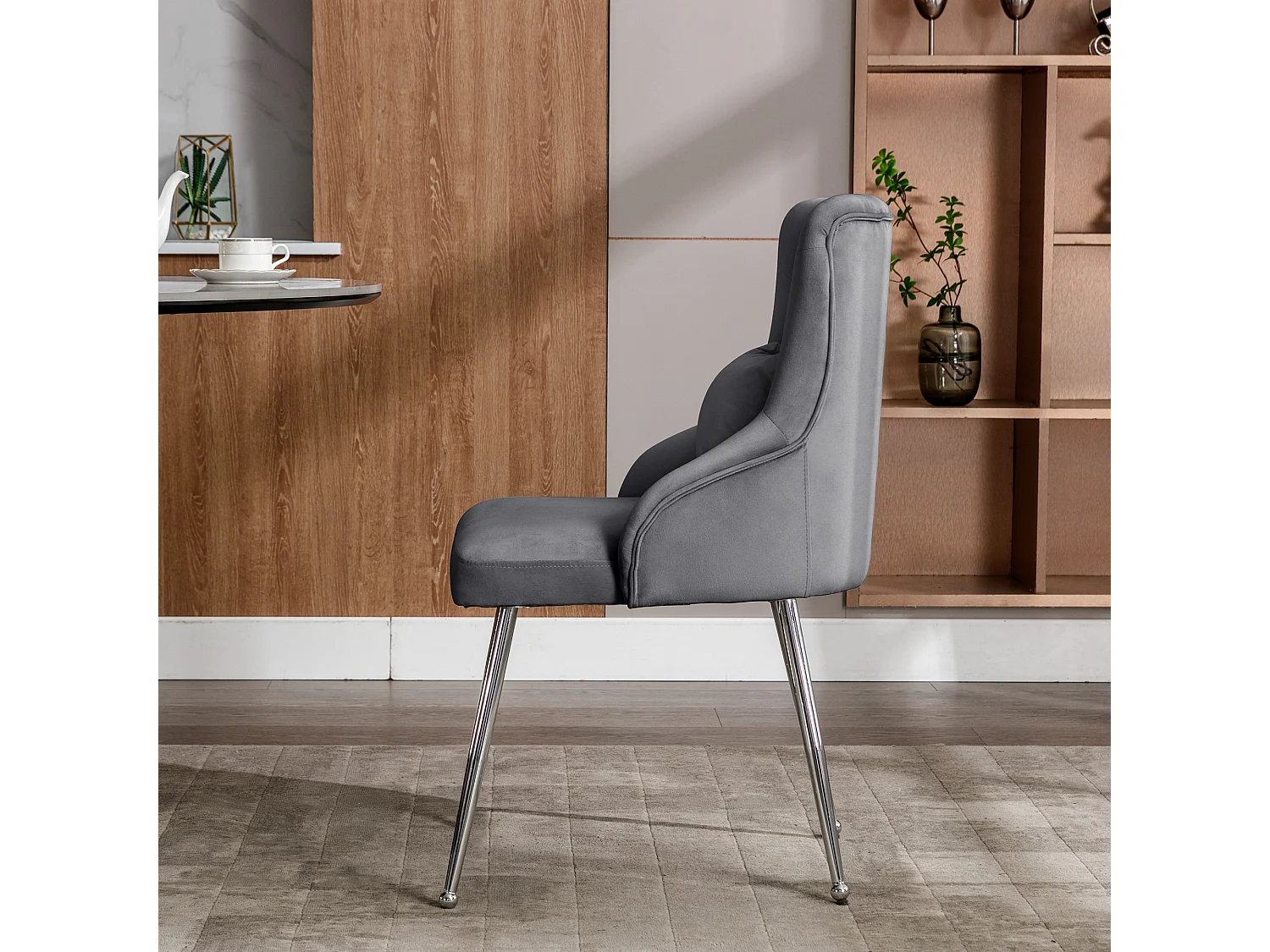 Silla de comedor de terciopelo gris con cojín lumbar y diseño moderno y patas de metal.