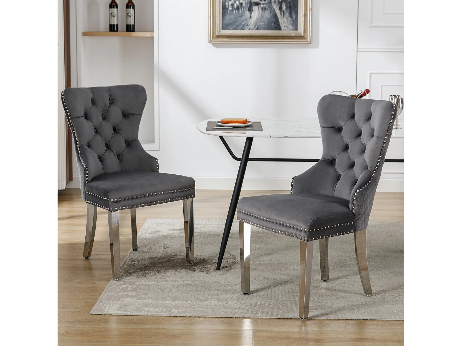Ensemble de 2 chaises gris velours, dossier motif heurtoir et garniture cloutée. Siège rembourré, pieds métal. Style rétro et confortable.