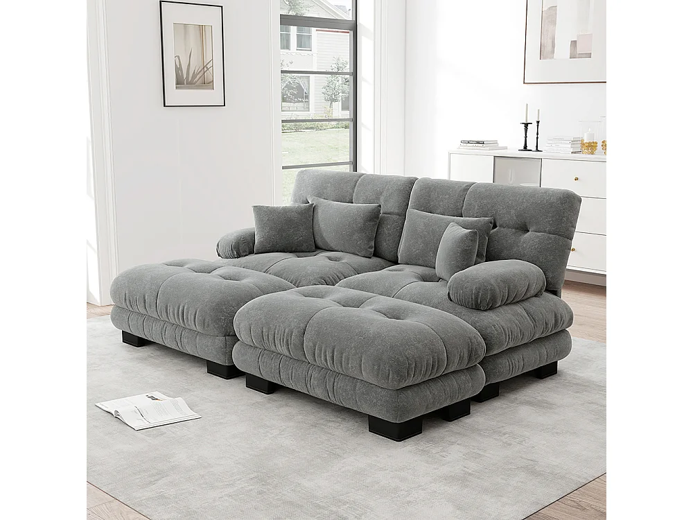 Divano a due posti in ciniglia, due cuscini lombari e due cuscini decorativi, braccioli larghi e due poggiapiedi, rivestimento in tessuto grigio.