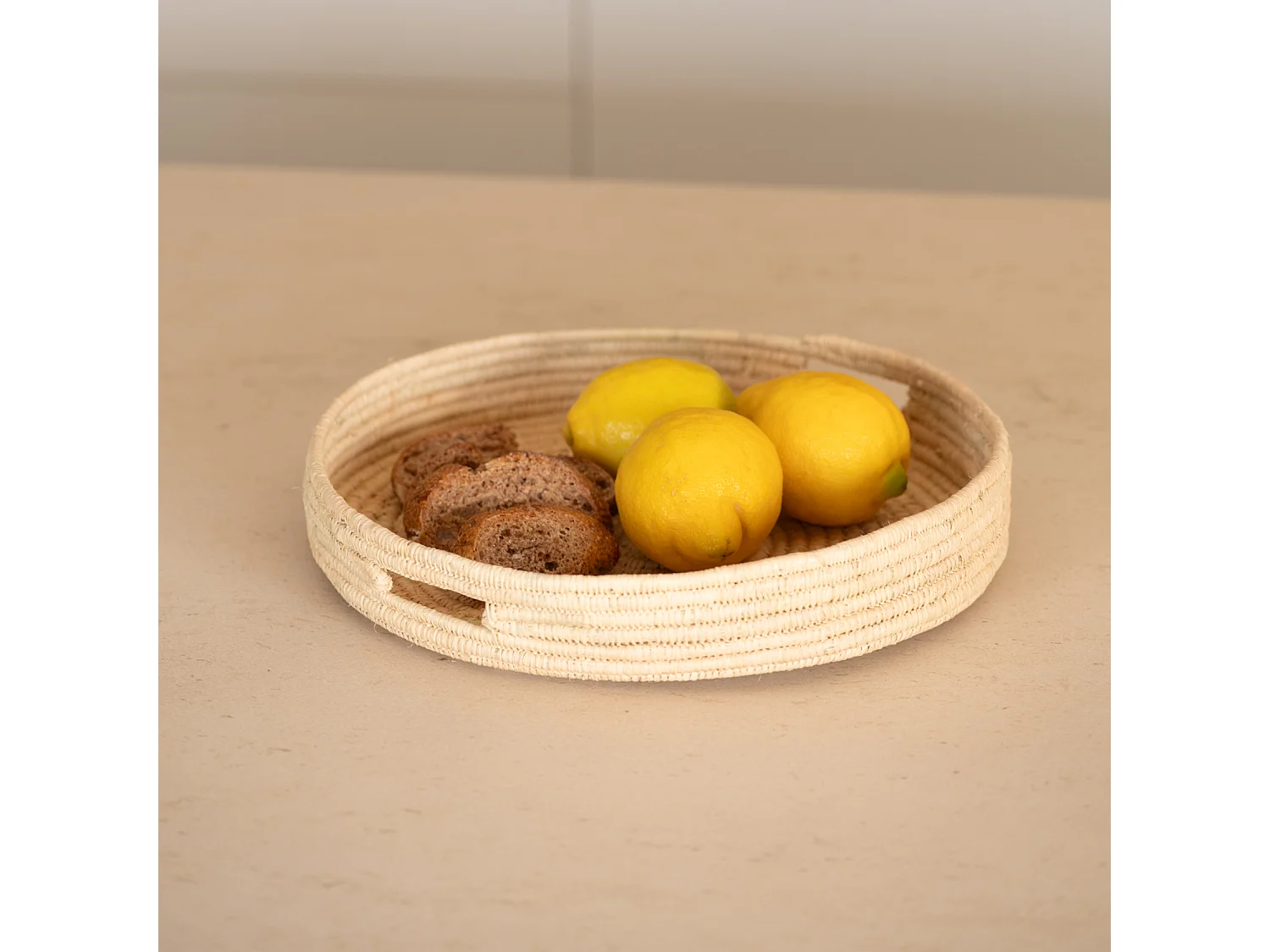 Bandeja redonda de mimbre natural con asas