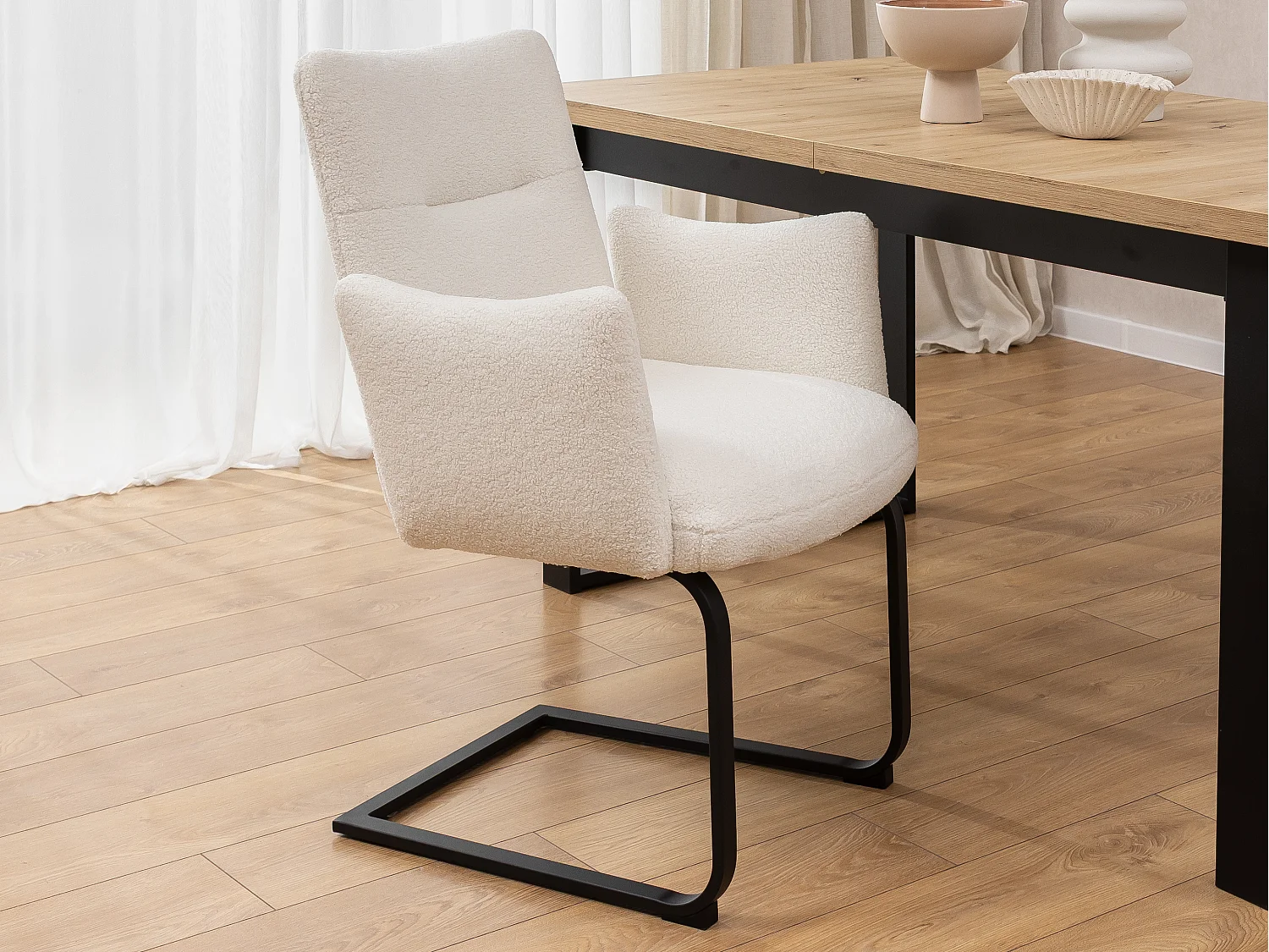 Chaise rembourrée au design moderne, en bouclé blanc, avec accoudoirs et piètement luge en métal noir - Hera