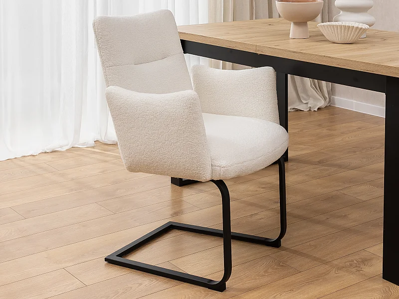 Chaise rembourrée au design moderne, en bouclé blanc, avec accoudoirs et piètement luge en métal noir - Hera