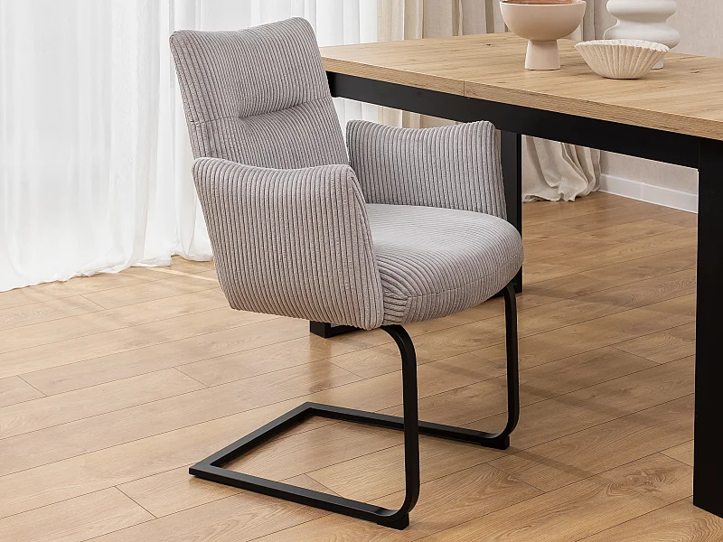 Chaise rembourrée au design moderne, en velours côtelé gris, avec accoudoirs et piètement luge en métal noir - Hera