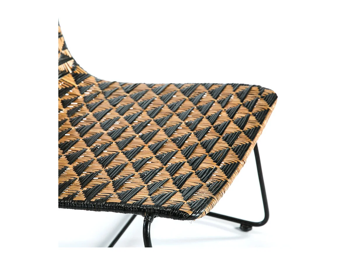 Sillón de mimbre negro y claro con patas de metal negro