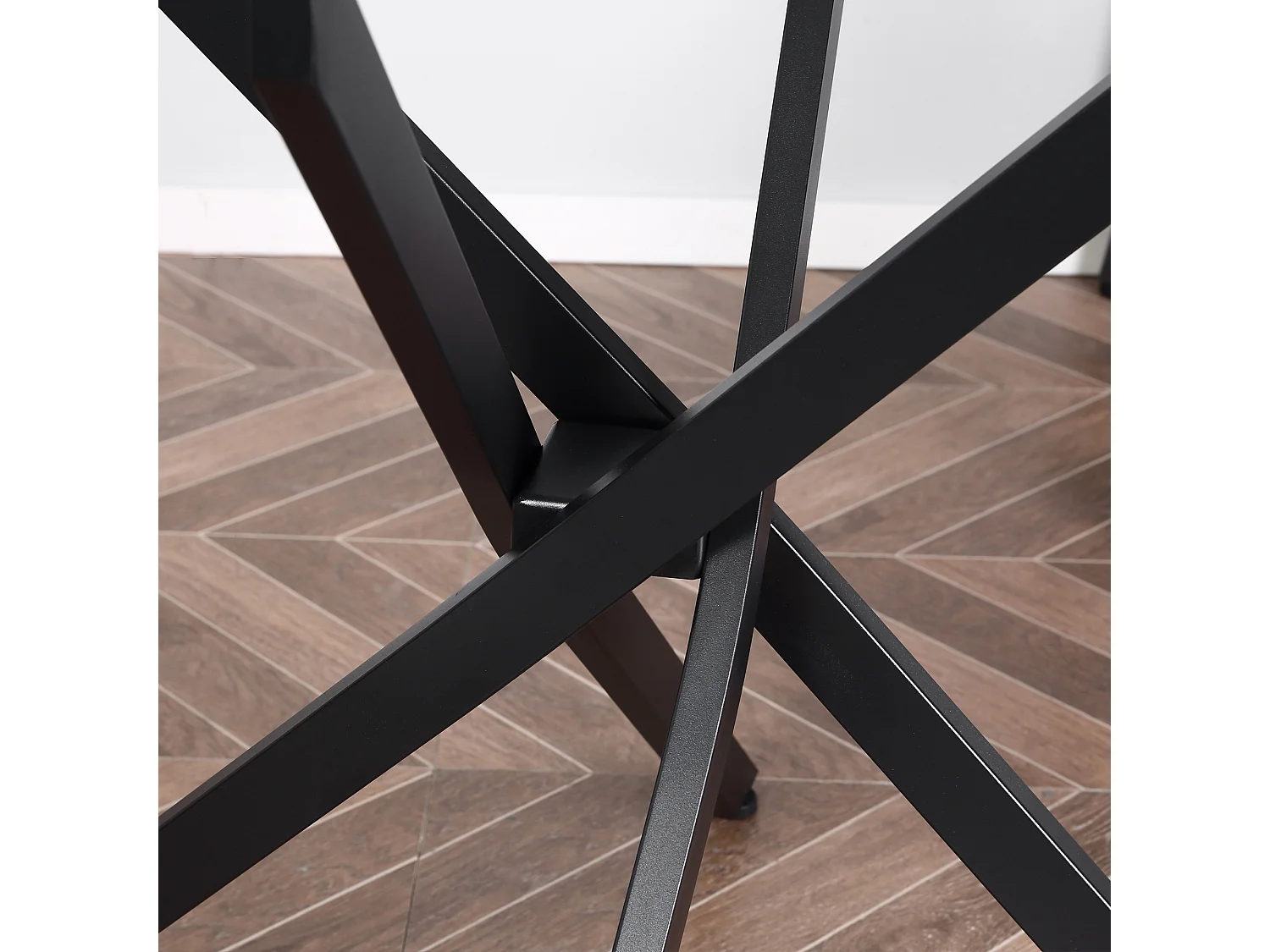 Tavolo da pranzo rotondo in vetro e gambe incrociate in metallo