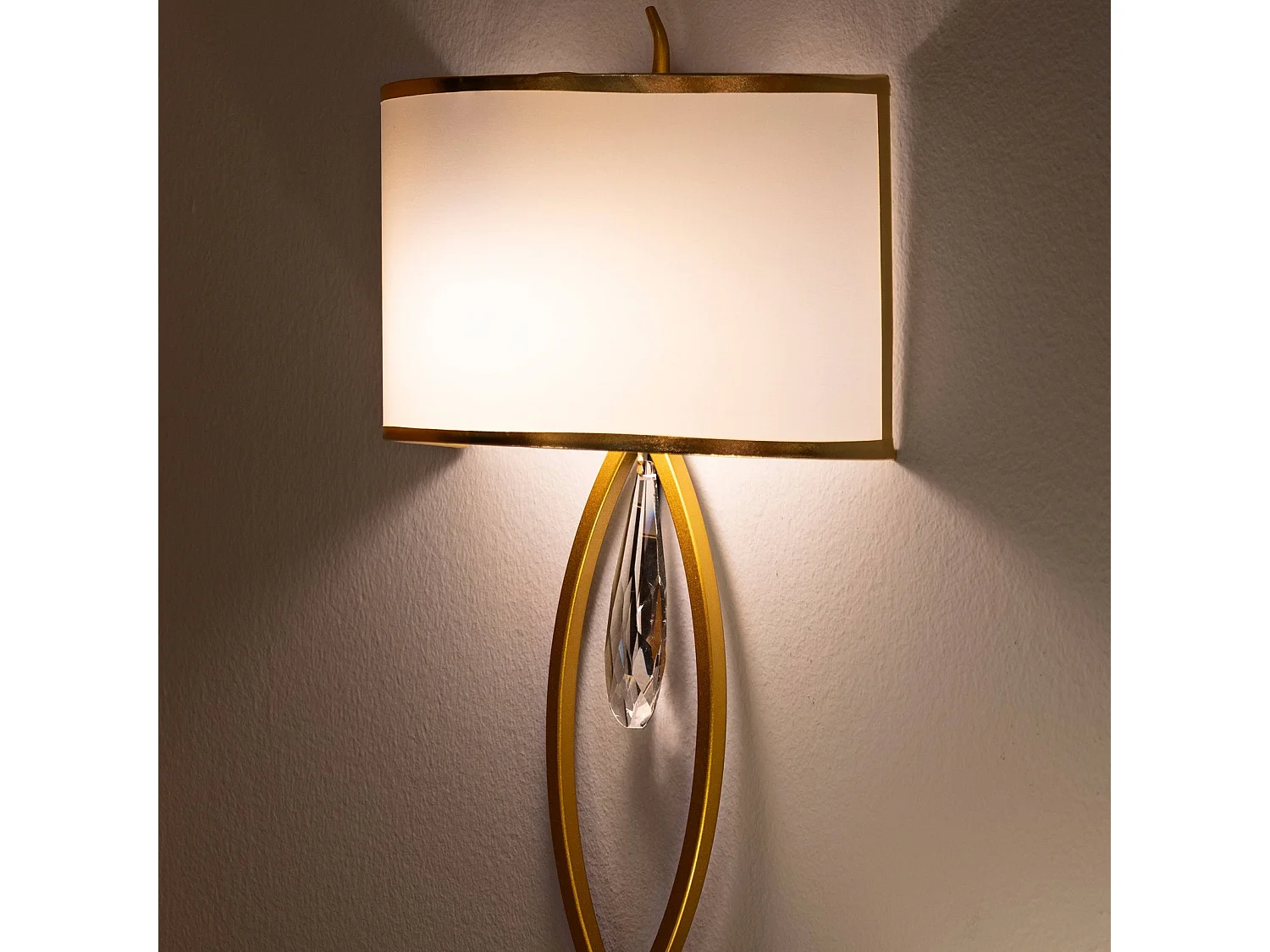 Wandlamp van metaal, glas en goud-witte stof.