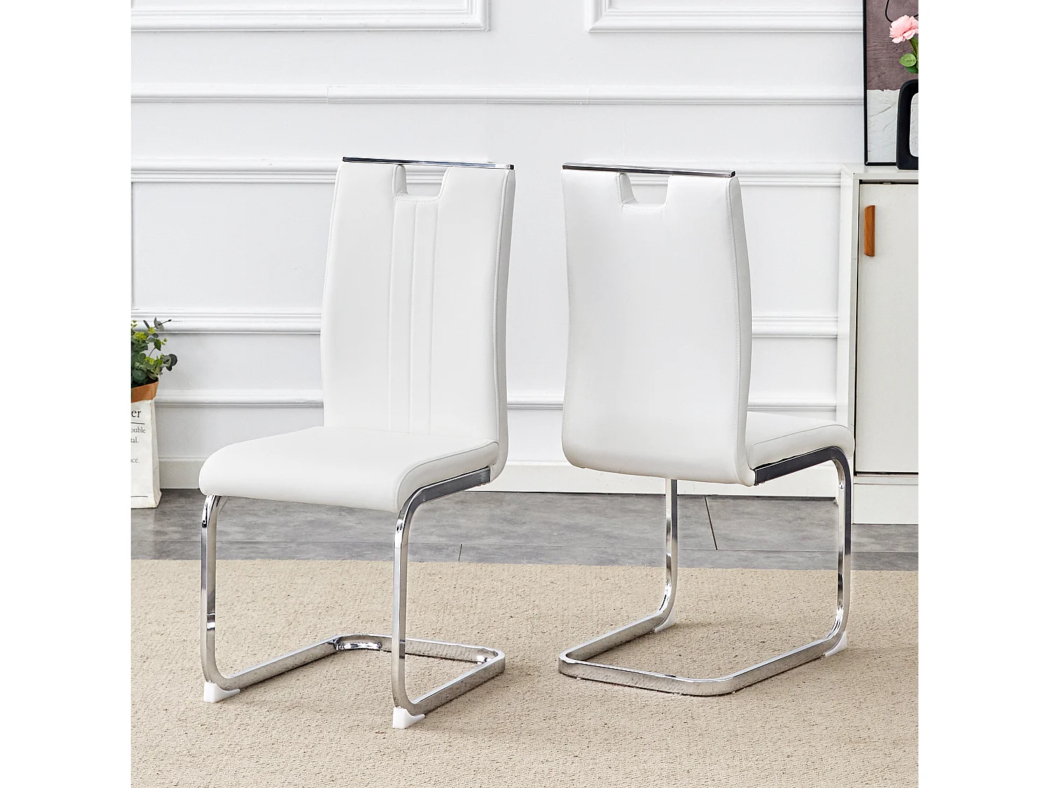 Set van 2 witte stoelen van PU-kunstleer met zilverkleurig metalen frame.