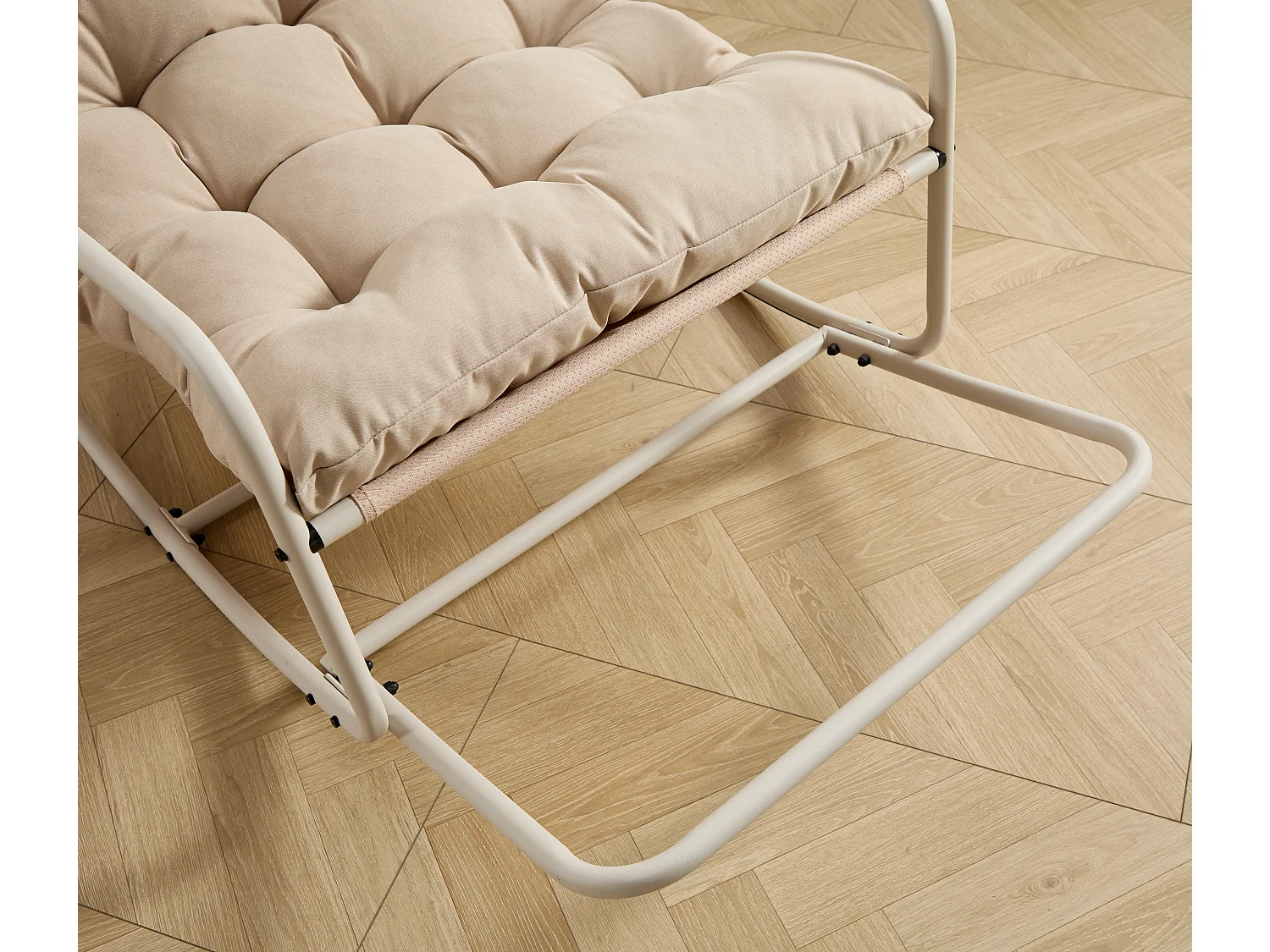 Stalen schommelstoel voor in de tuin met beige kussen
