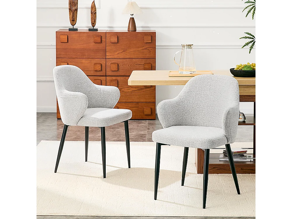 Set van twee eetkamerstoelen, met kruisvormige metalen poten en een brede, omhullende rugleuning, lichtgrijs