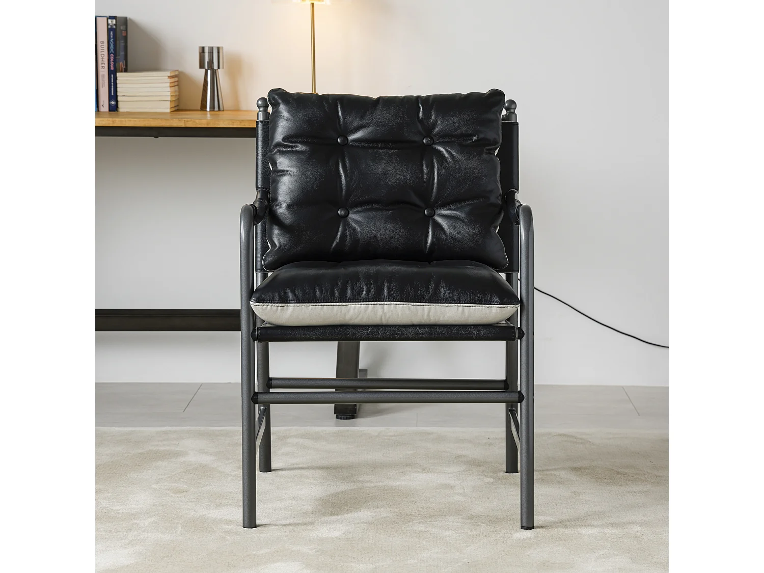 Sillón moderno de cuero negro con estructura metálica
