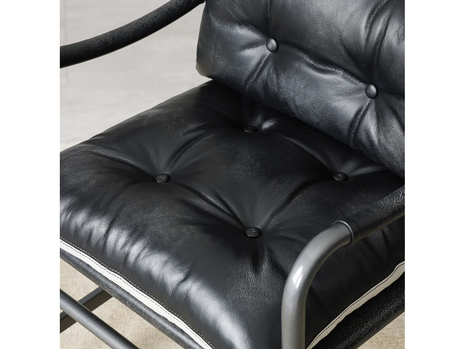 Sillón moderno de cuero negro con estructura metálica