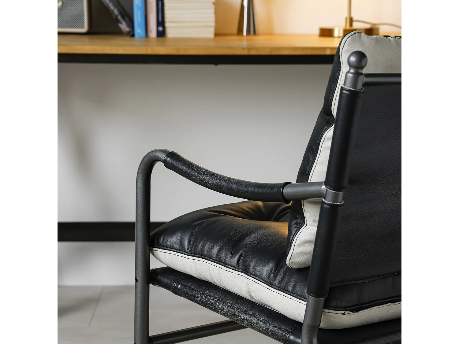 Sillón moderno de cuero negro con estructura metálica