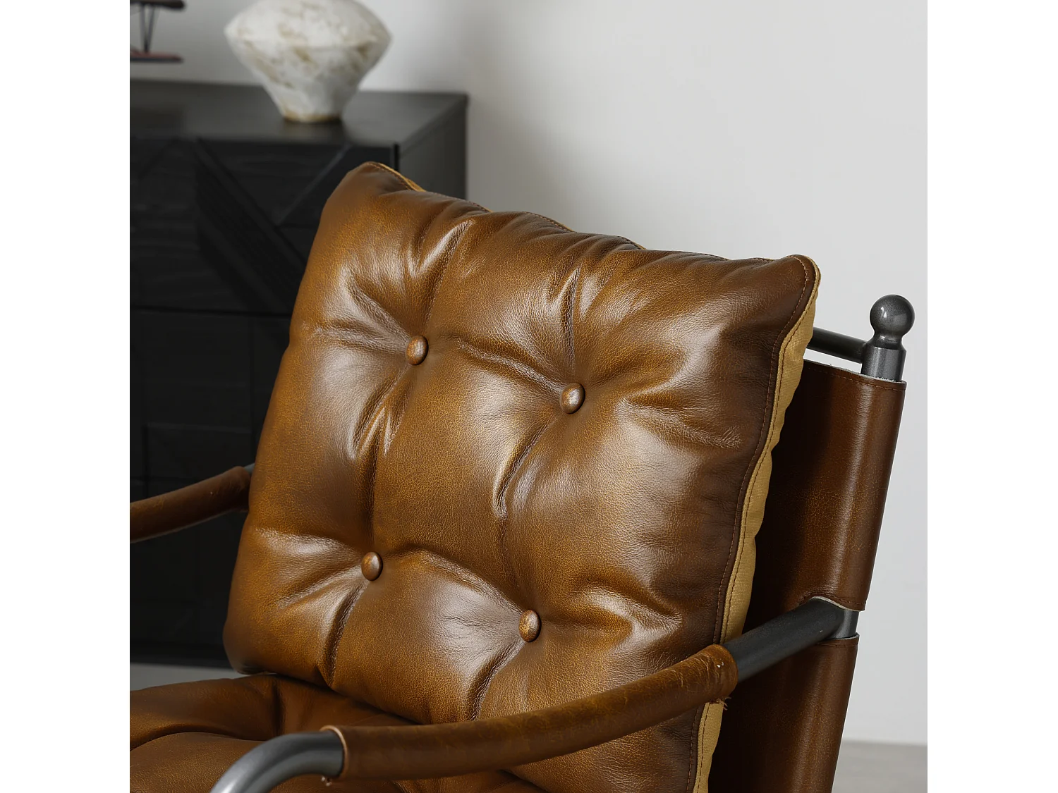 Sillón moderno de cuero marrón con estructura metálica