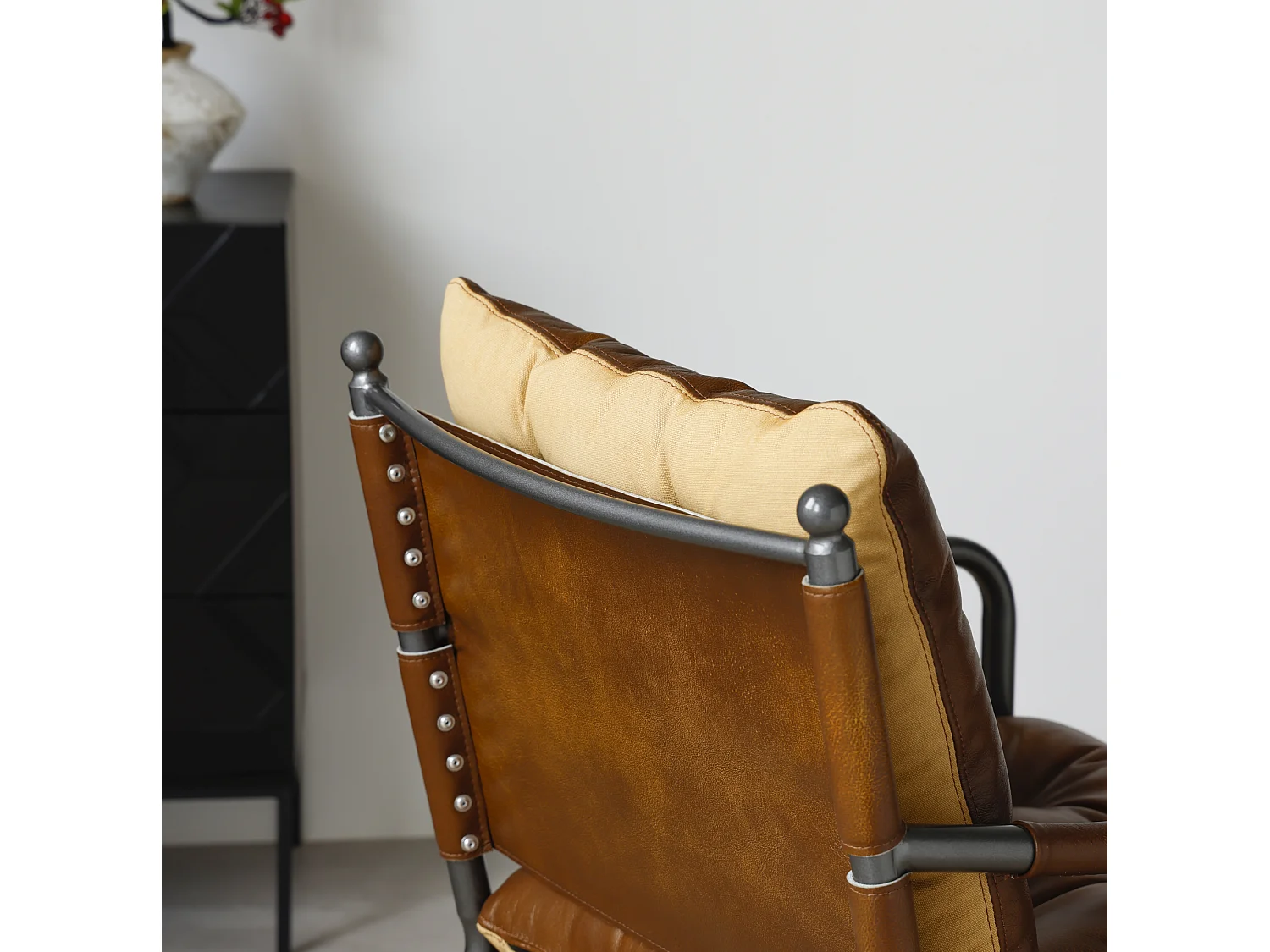 Sillón moderno de cuero marrón con estructura metálica
