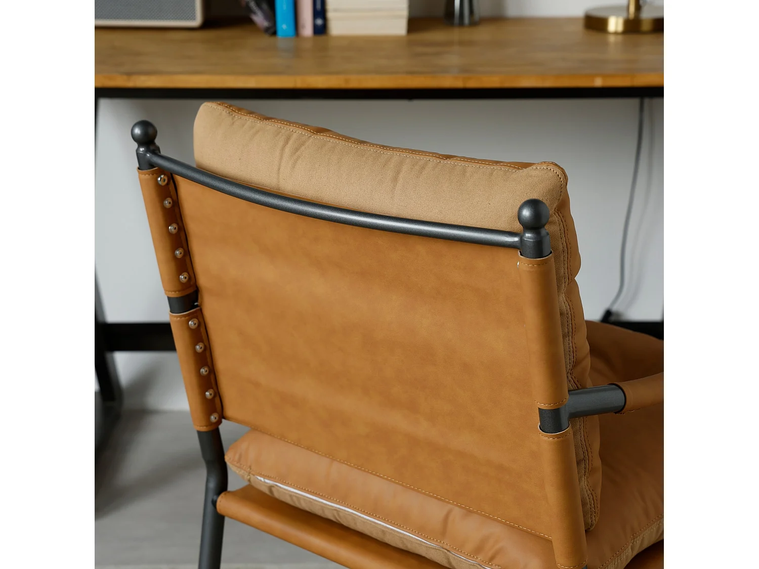 Vintage loungestoel met PU leereffect, knoopstiksels, armleuningen en metalen frame